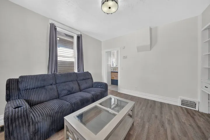 Recessed lighting fixture, wood-finish flooring, built-in shelving, and white baseboard trim