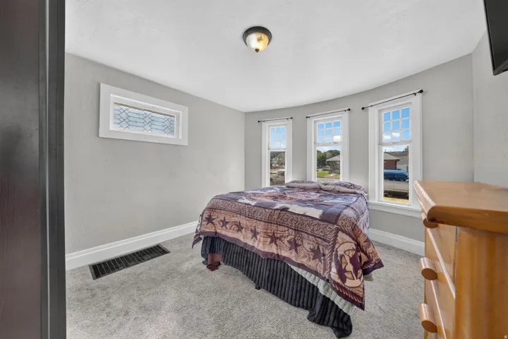 Carpeted room featuring multiple windows, a decorative transom window, and a ceiling-mounted light fixture