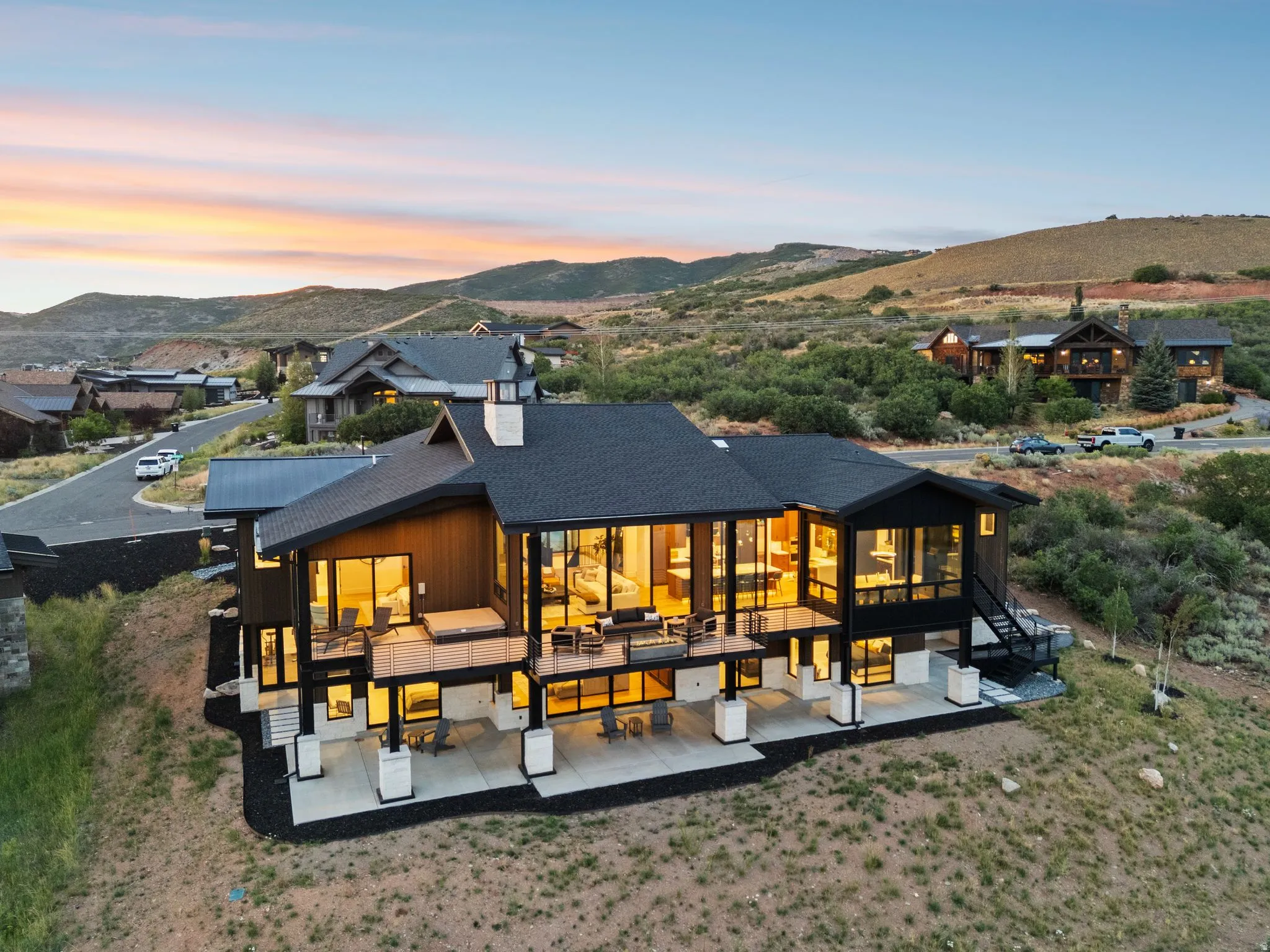 Terraced outdoor spaces featuring multiple patios and balconies, a built-in spa, and extensive window walls