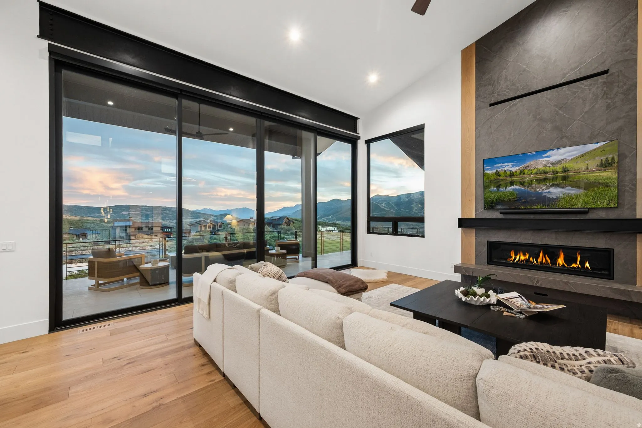 Expansive sliding glass doors, vaulted ceilings, and wood-finish flooring