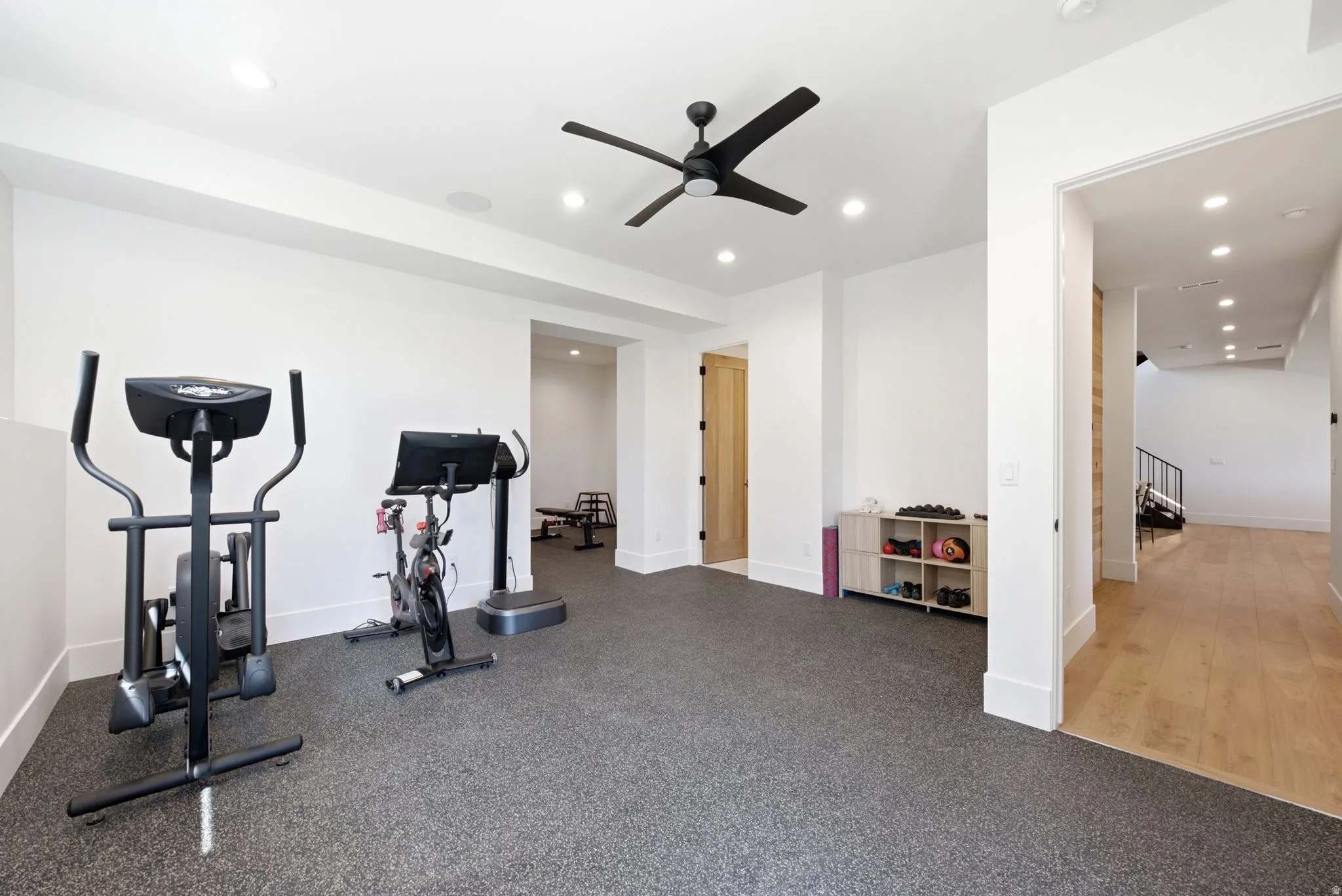 Spacious room with durable rubber flooring, recessed lighting, and a ceiling fan