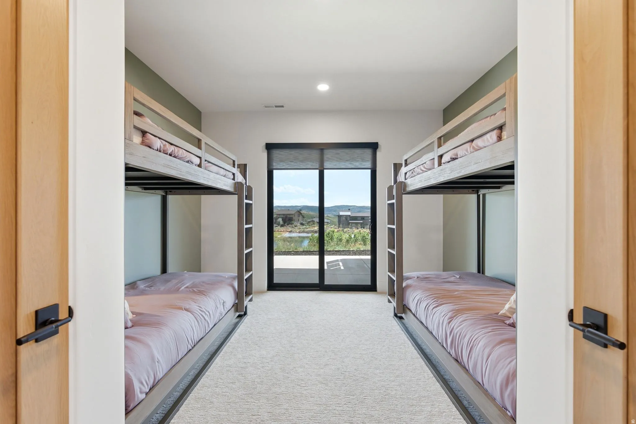 Recessed lighting, light wood-finish doors, black hardware, carpeted flooring, sliding glass door