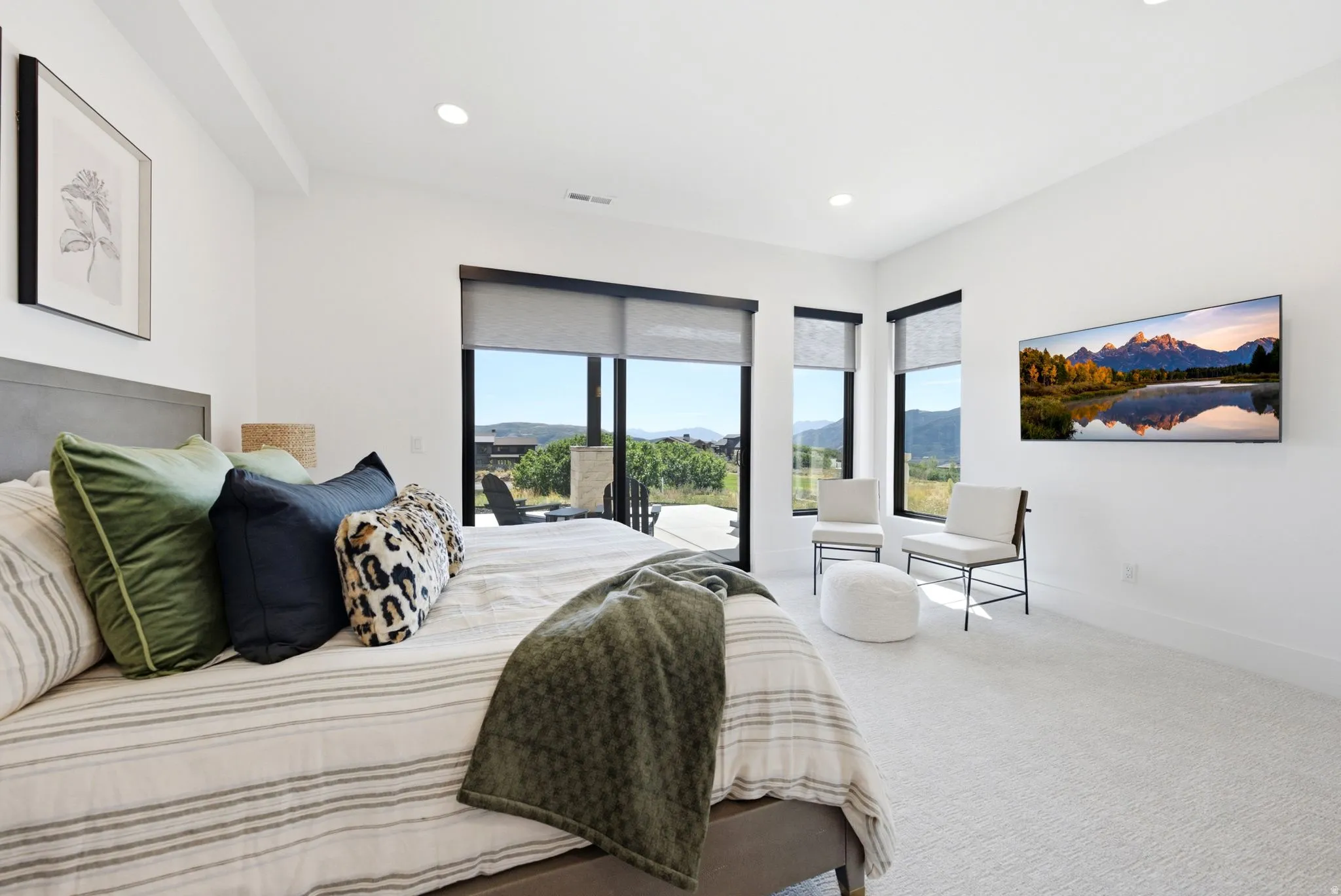 Recessed lighting, large format windows with roller shades, and light-toned carpeting