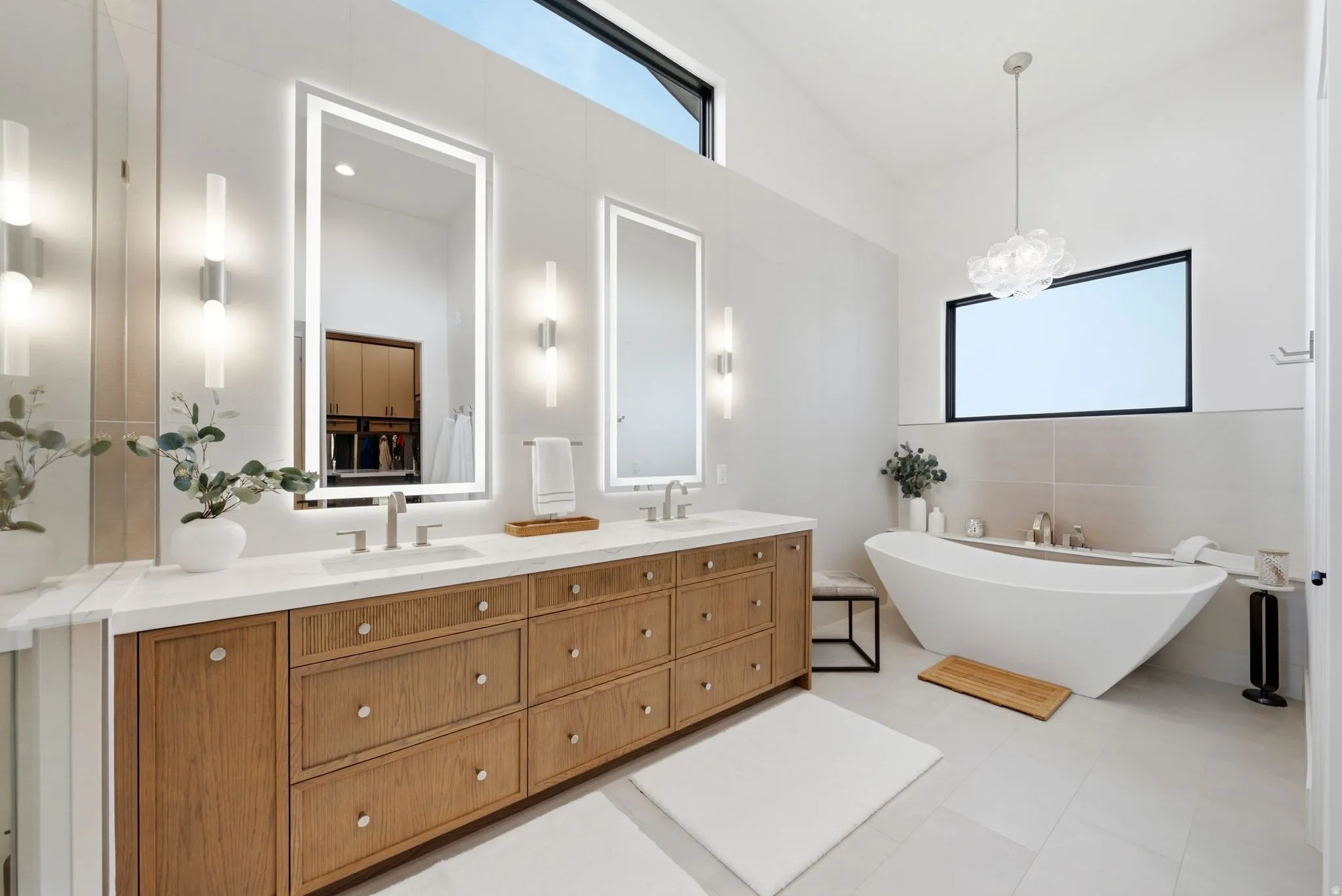 Double vanity with wood-finish cabinetry, white stone countertop, and undermount sinks