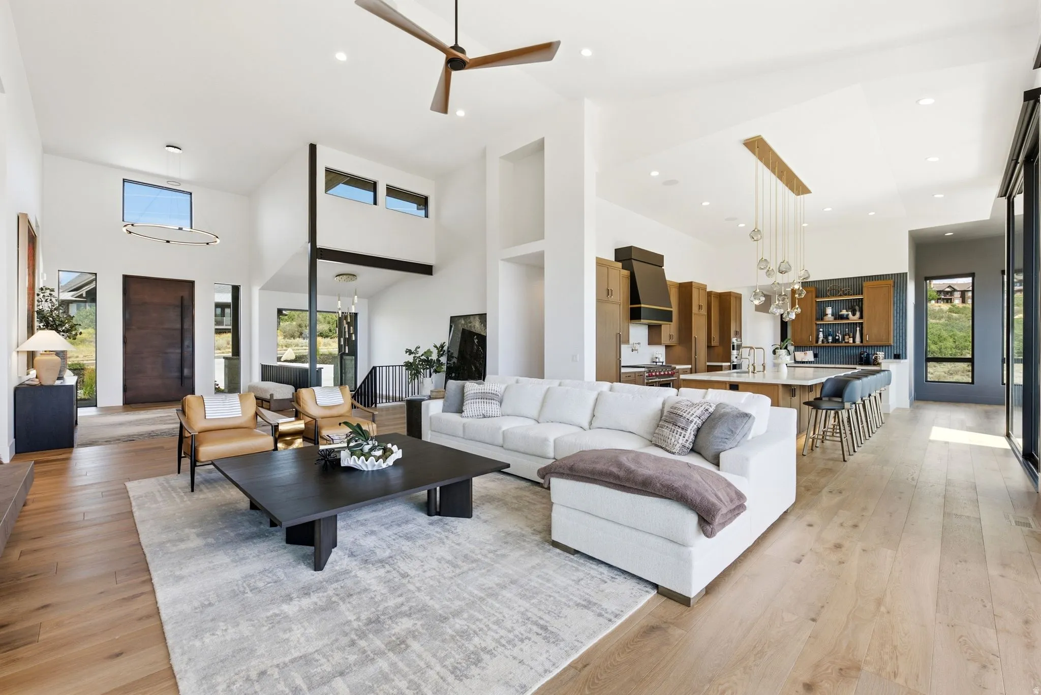 Vaulted ceilings, wood-finish flooring, and a modern kitchen with an island and built-in cabinetry