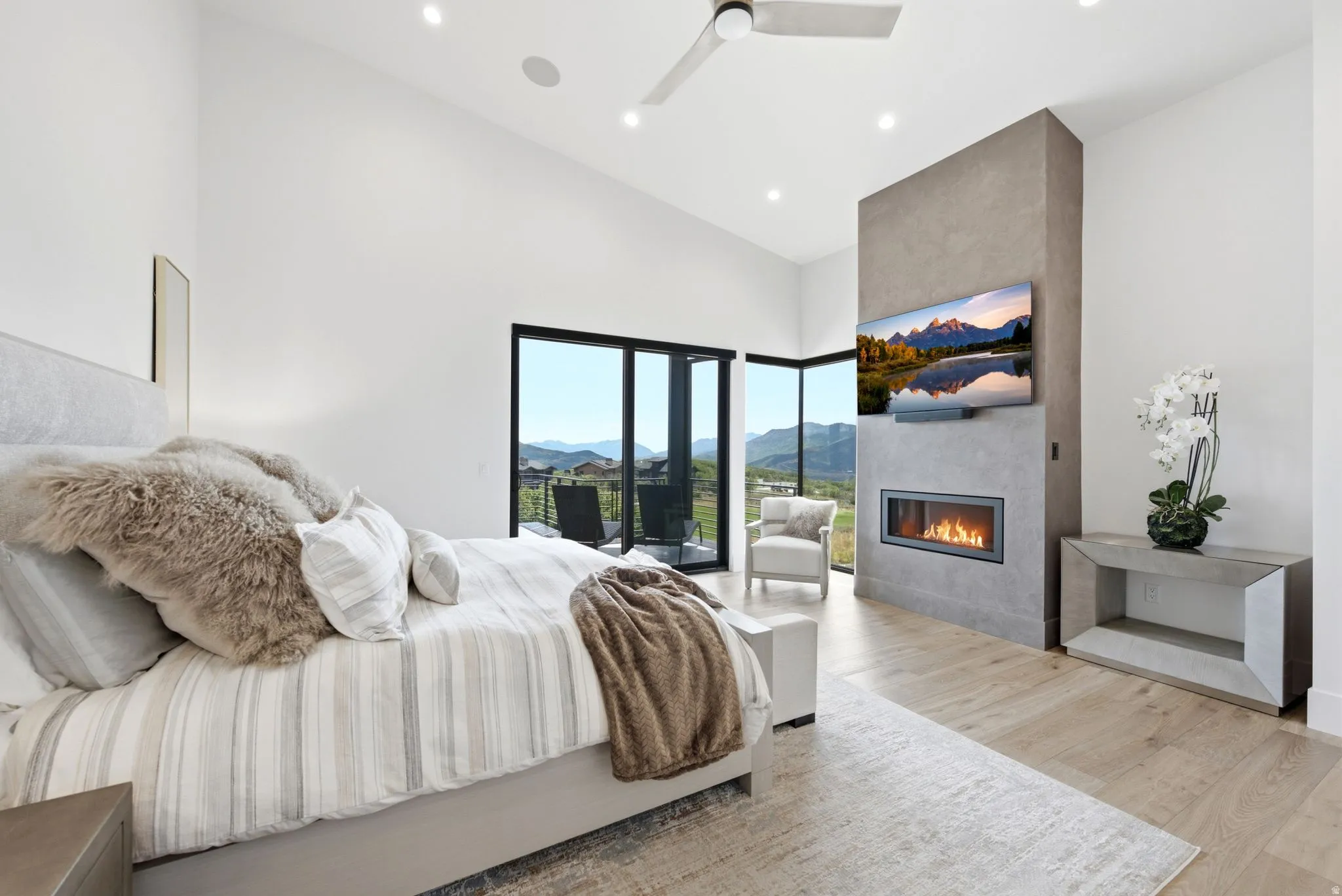 Vaulted ceiling, recessed lighting, expansive glass doors, built-in fireplace, and wood-finish flooring