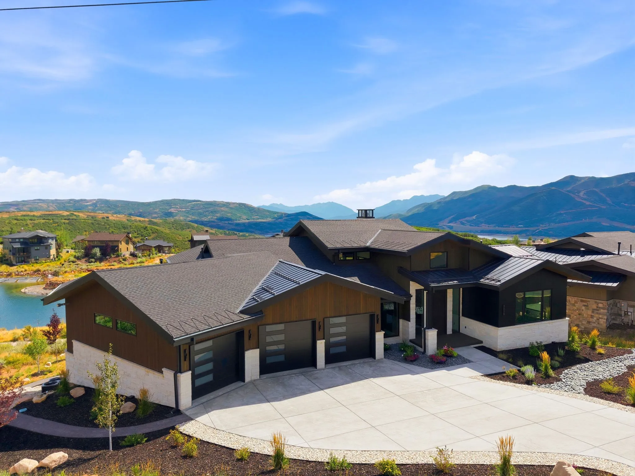 Modern exterior featuring a dark-toned roof, wood-finish siding, and stone accents