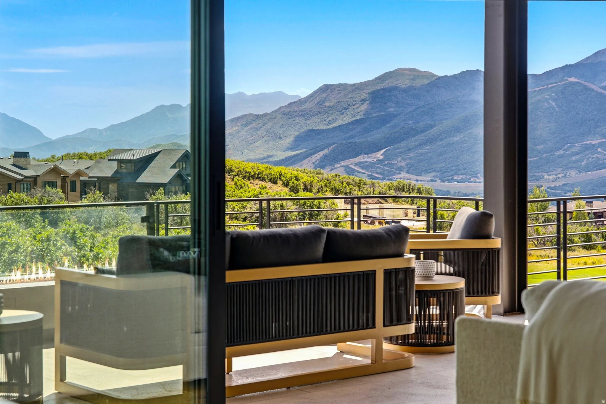 Expansive outdoor deck with glass panel railing and mountain scenery