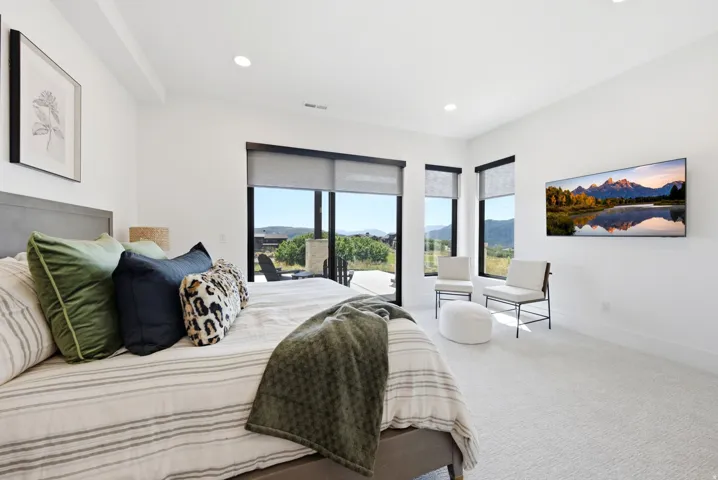Recessed lighting, large format windows with roller shades, and light-toned carpeting