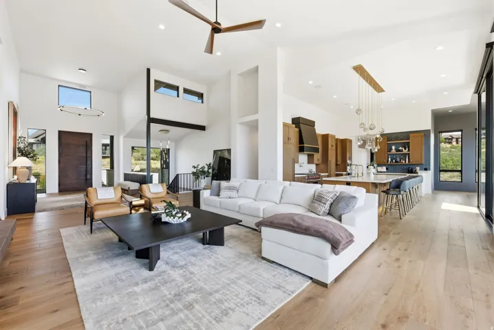 Vaulted ceilings, wood-finish flooring, and a modern kitchen with an island and built-in cabinetry
