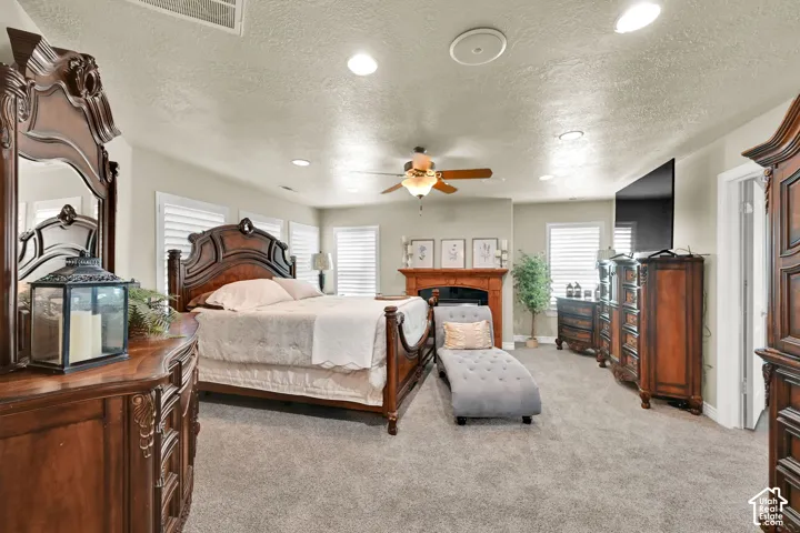 Owner's Suite spacious room with recessed lighting, ceiling fan, and fireplace