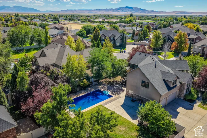Stunning residential estate featuring a resort-style swimming pool with  mature landscaping with mixed tree varieties, and a  stone and stucco exterior