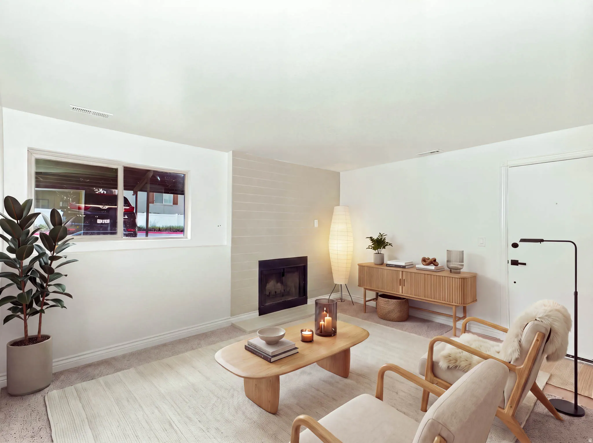 Built-in fireplace with a dark surround, light-colored brick-patterned accent wall, white walls, and a window with white trim