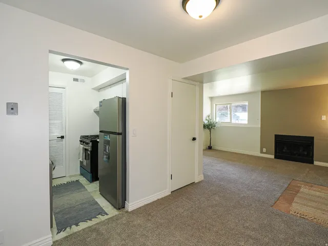 Recessed kitchen featuring stainless steel refrigerator, black range, and tile flooring