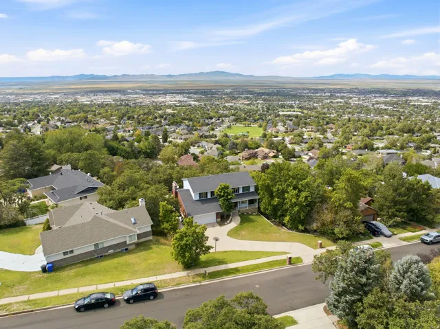 Expansive residential property featuring a multi-level home with a covered front porch and a paved driveway