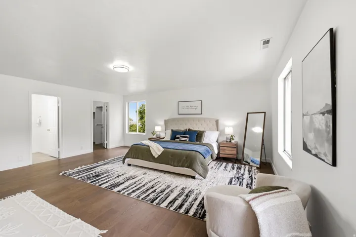 Dark wood-finish flooring with white walls and a contemporary ceiling light fixture