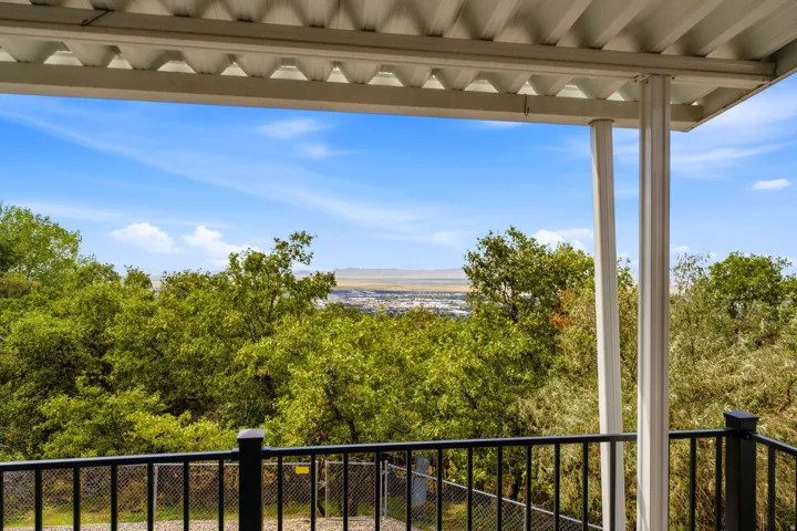 Covered balcony with white supports and a black railing