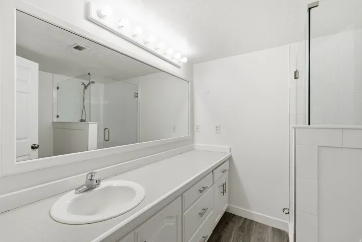 Vanity with integrated sink, chrome faucet, and expansive wall-mounted mirror