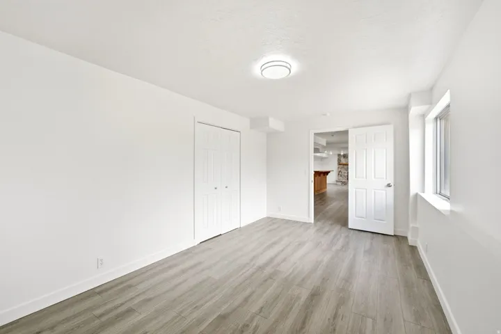 Wood-finish flooring, white paneled bifold closet doors, and recessed window