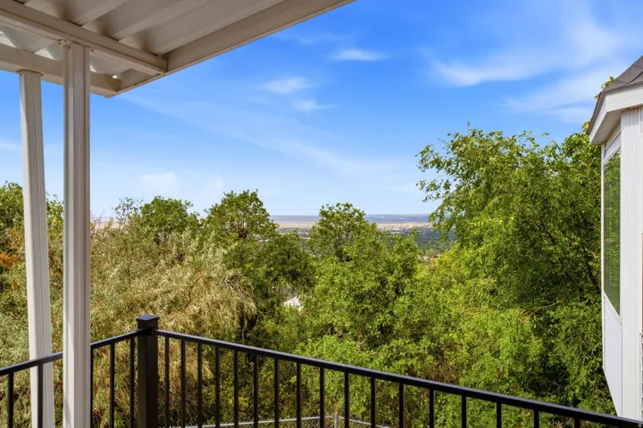 Covered balcony with black metal railings and overhead structure