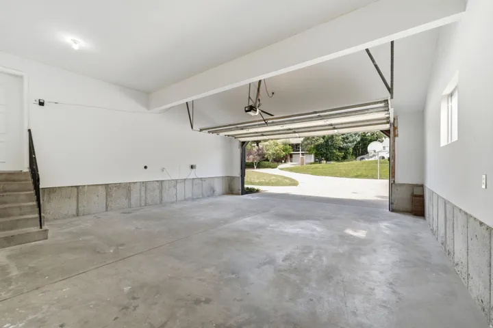 Spacious two-car garage with concrete flooring and exposed concrete block walls