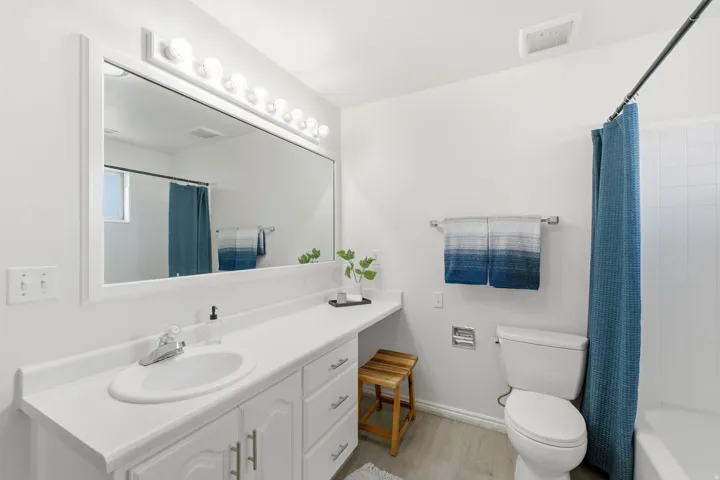Built-in vanity with a single basin, laminate countertop, and ample storage cabinetry