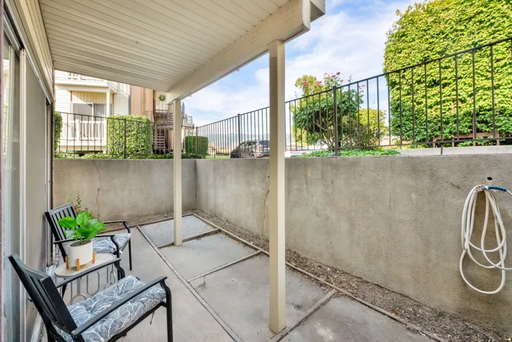 Covered outdoor patio with a concrete surface, supported by white columns