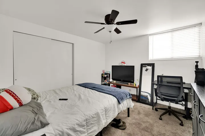 Recessed window with blinds, ceiling fan, and carpeted flooring