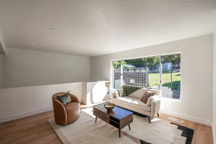 Recessed lighting illuminates an open-concept room featuring light wood-finish flooring