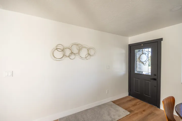 Entryway featuring wood-finish flooring and a dark-paneled door with decorative glass