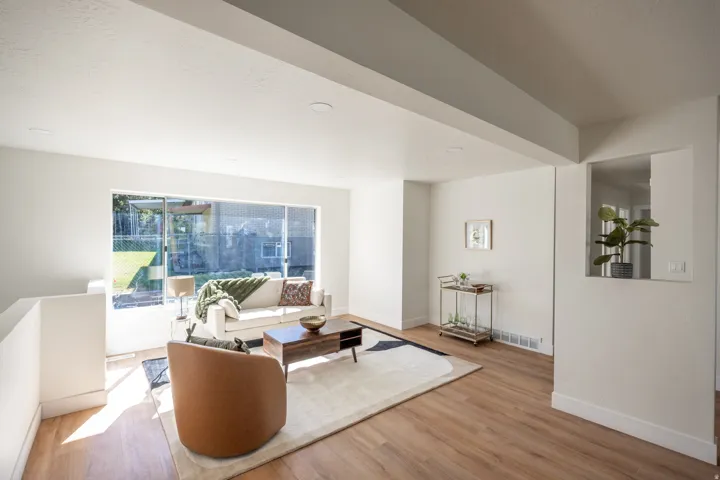 Spacious living area featuring expansive windows, wood-finish flooring, recessed lighting, and a built-in wall niche
