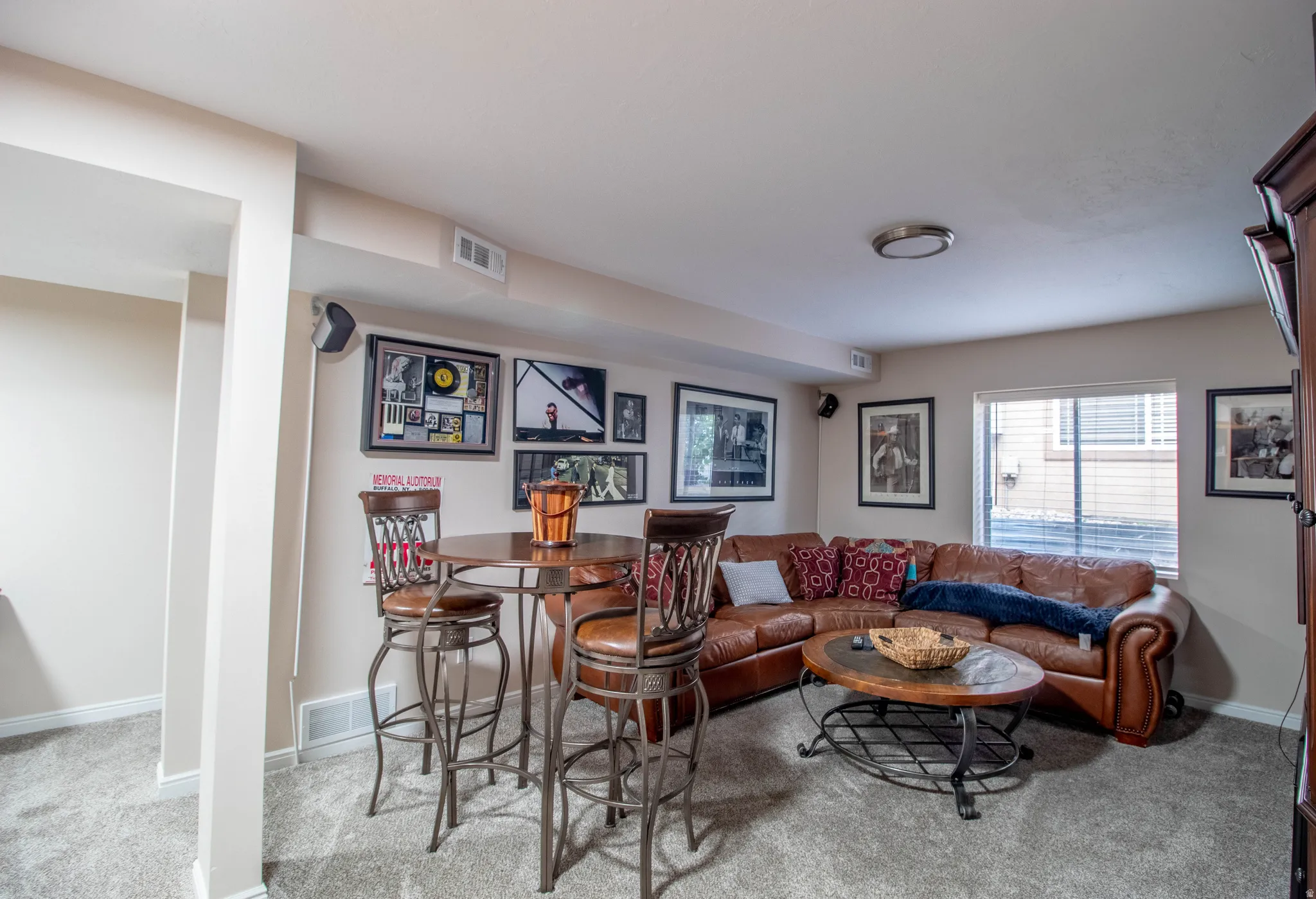 Carpeted recreational space with a window, built-in shelving, and recessed lighting