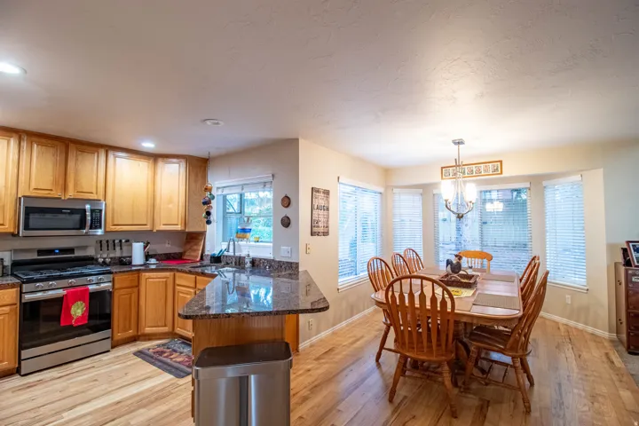 Kitchen with wood-finish flooring, stainless steel appliances, and granite countertops