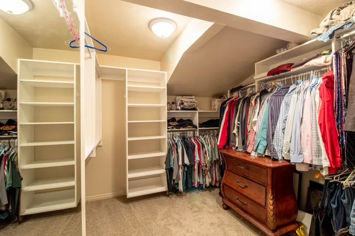 Custom closet system with multiple shelving units, hanging rods, and built-in storage