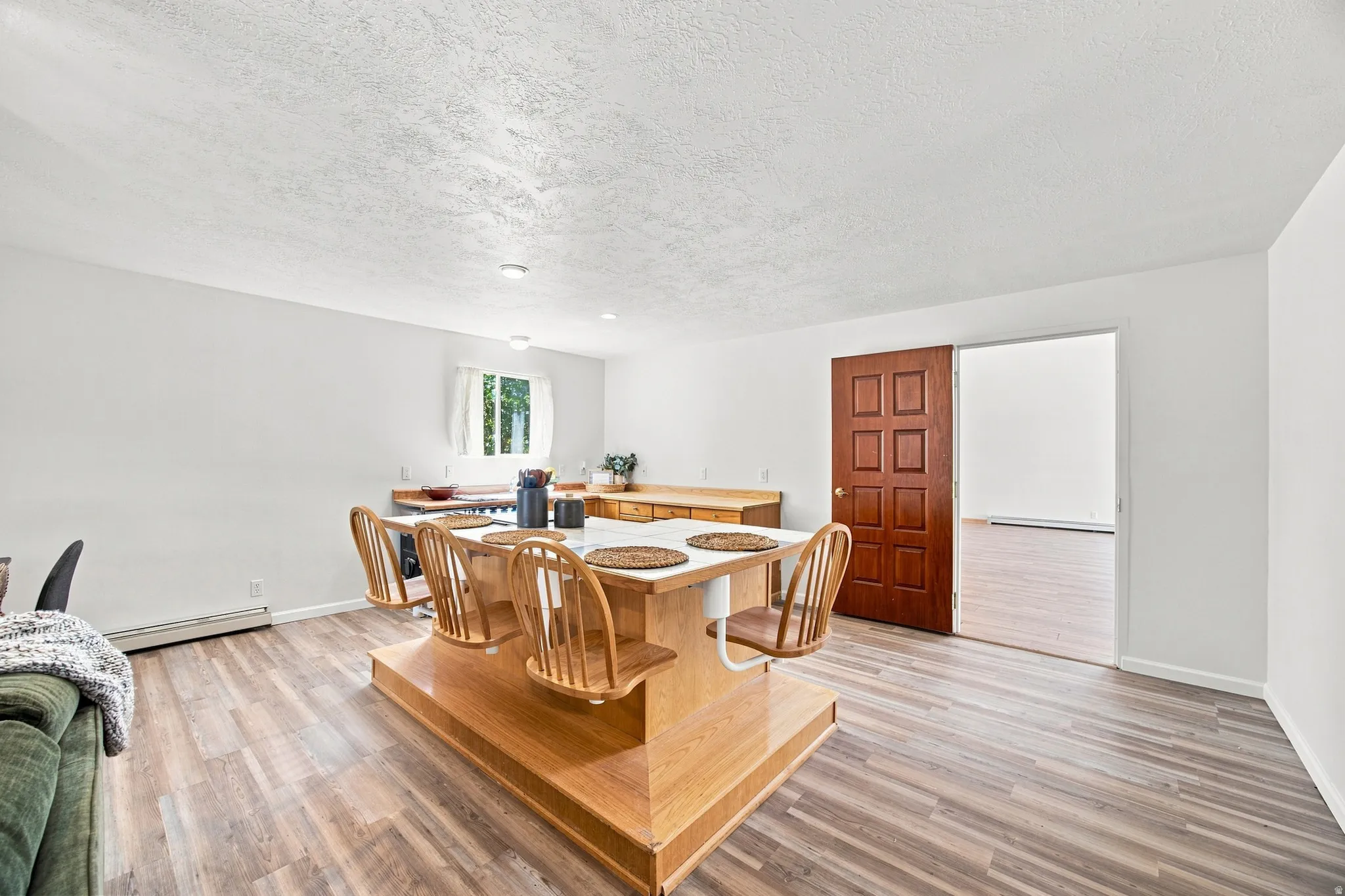 Wood-finish flooring throughout, with a built-in kitchen island featuring a light-toned countertop and lower storage