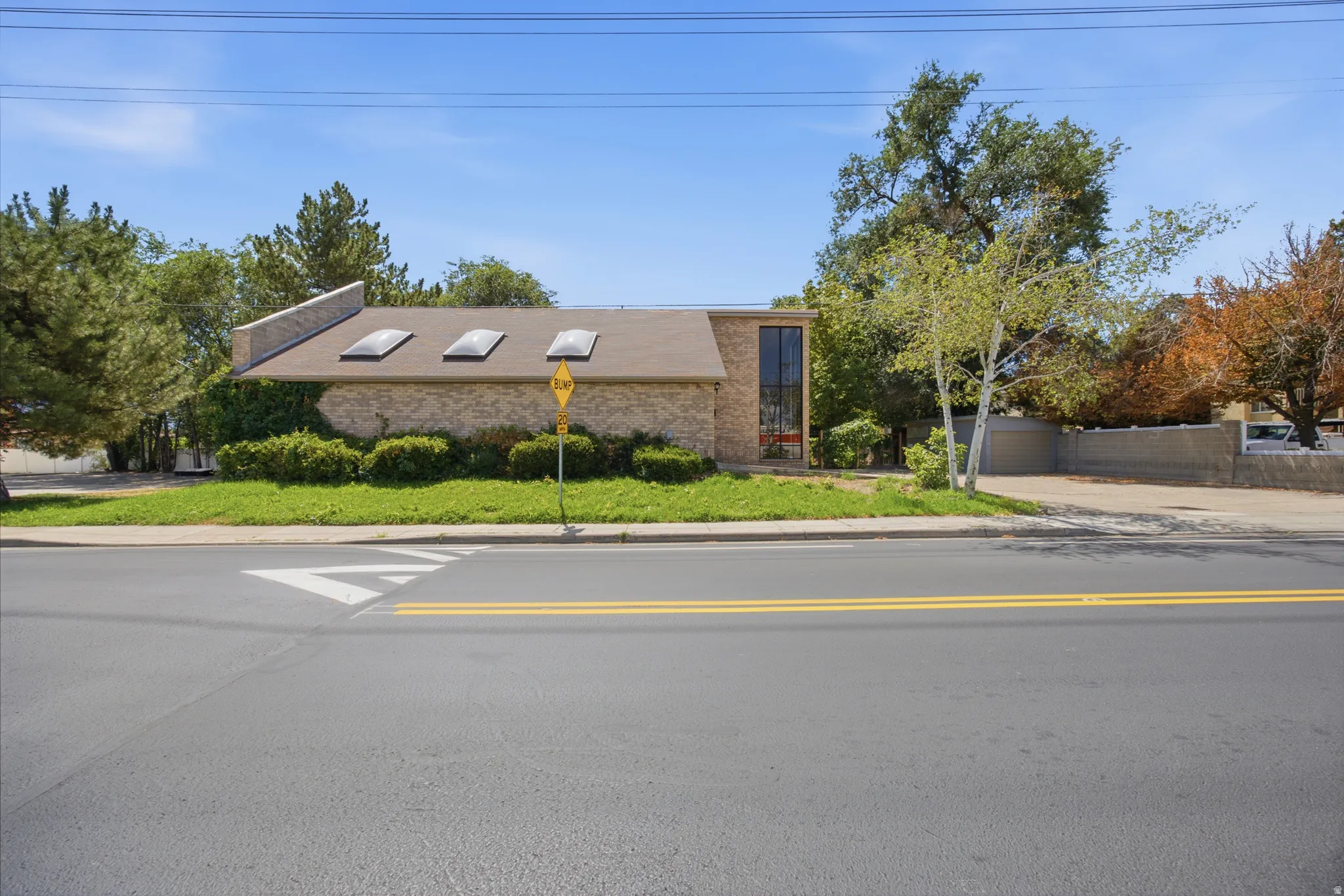 Brick exterior with a peaked roof and multiple skylights