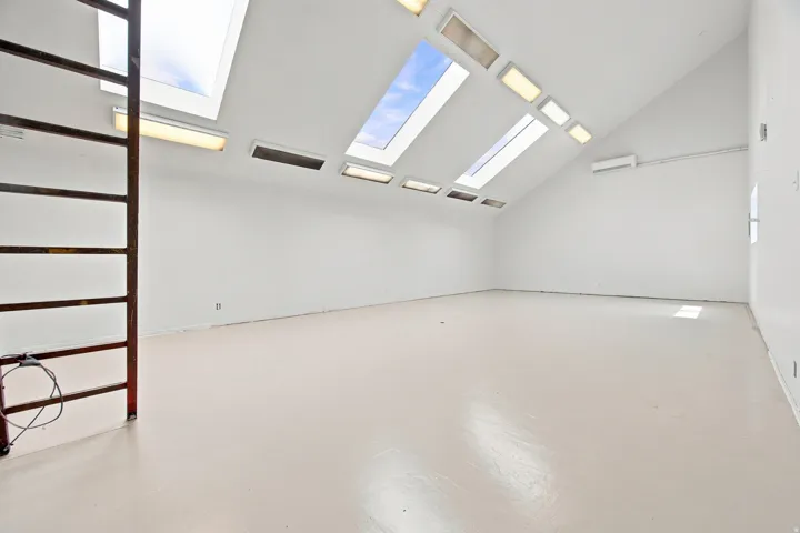 Vaulted ceiling featuring multiple skylights and recessed lighting