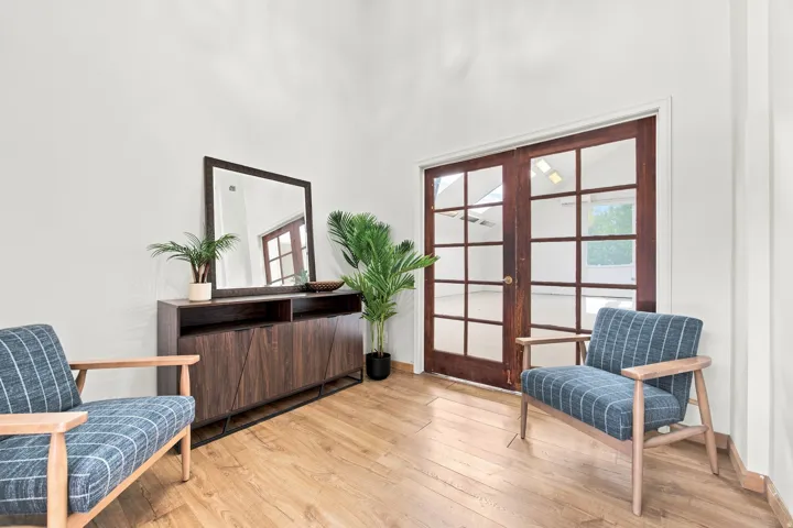 Wood-finish flooring throughout, featuring a vaulted white ceiling