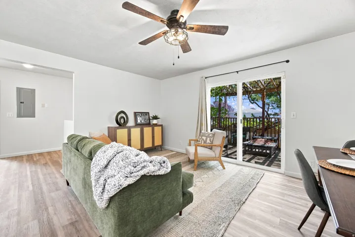 Hardwood-finish flooring, sliding glass door, overhead fan with integrated lighting, and white walls