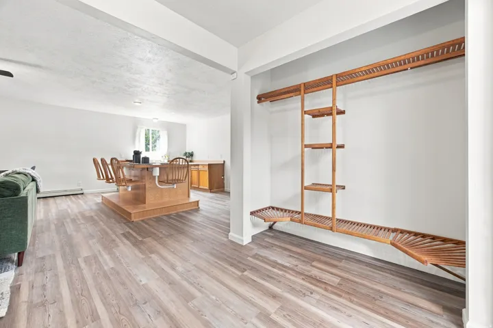 Wood-finish flooring throughout, white walls, and built-in closet shelving