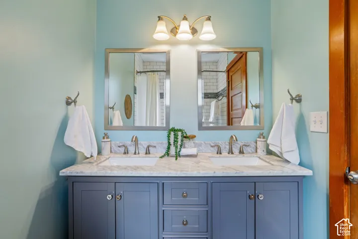 Dual vanity with a stone countertop, undermount sinks, and brushed nickel faucets