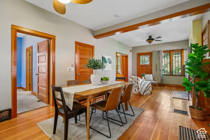 Hardwood flooring throughout, exposed wood beams, and a decorative ceiling fan
