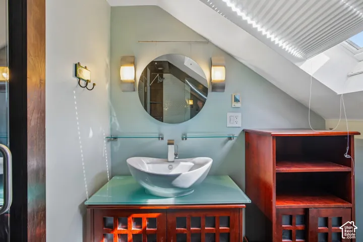 Modern vessel sink with chrome faucet, set on a glass-top vanity