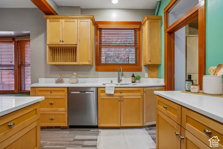 Wood-finish cabinetry and trim complement the light countertops
