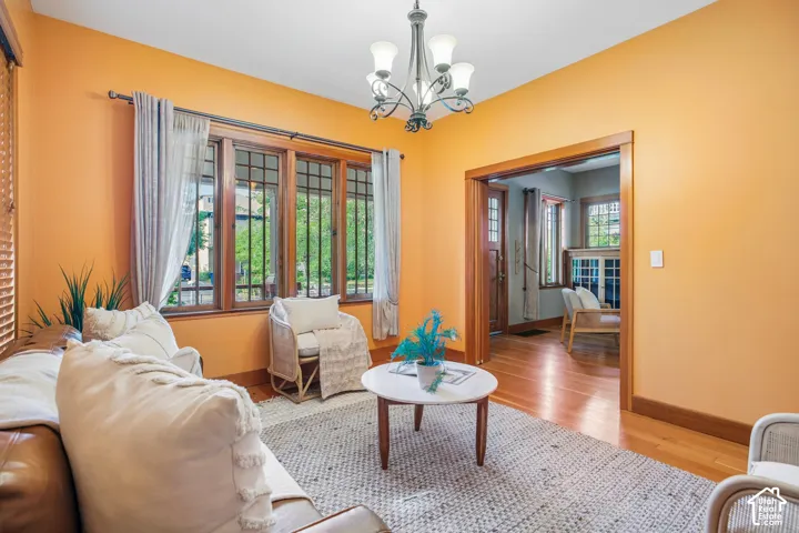 Hardwood flooring, wood-framed windows, wood trim, and a chandelier with glass shades