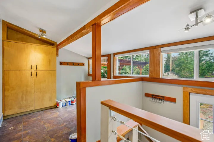 Built-in wood cabinetry with black hardware, track lighting, wood-trimmed windows, and wood-finish flooring