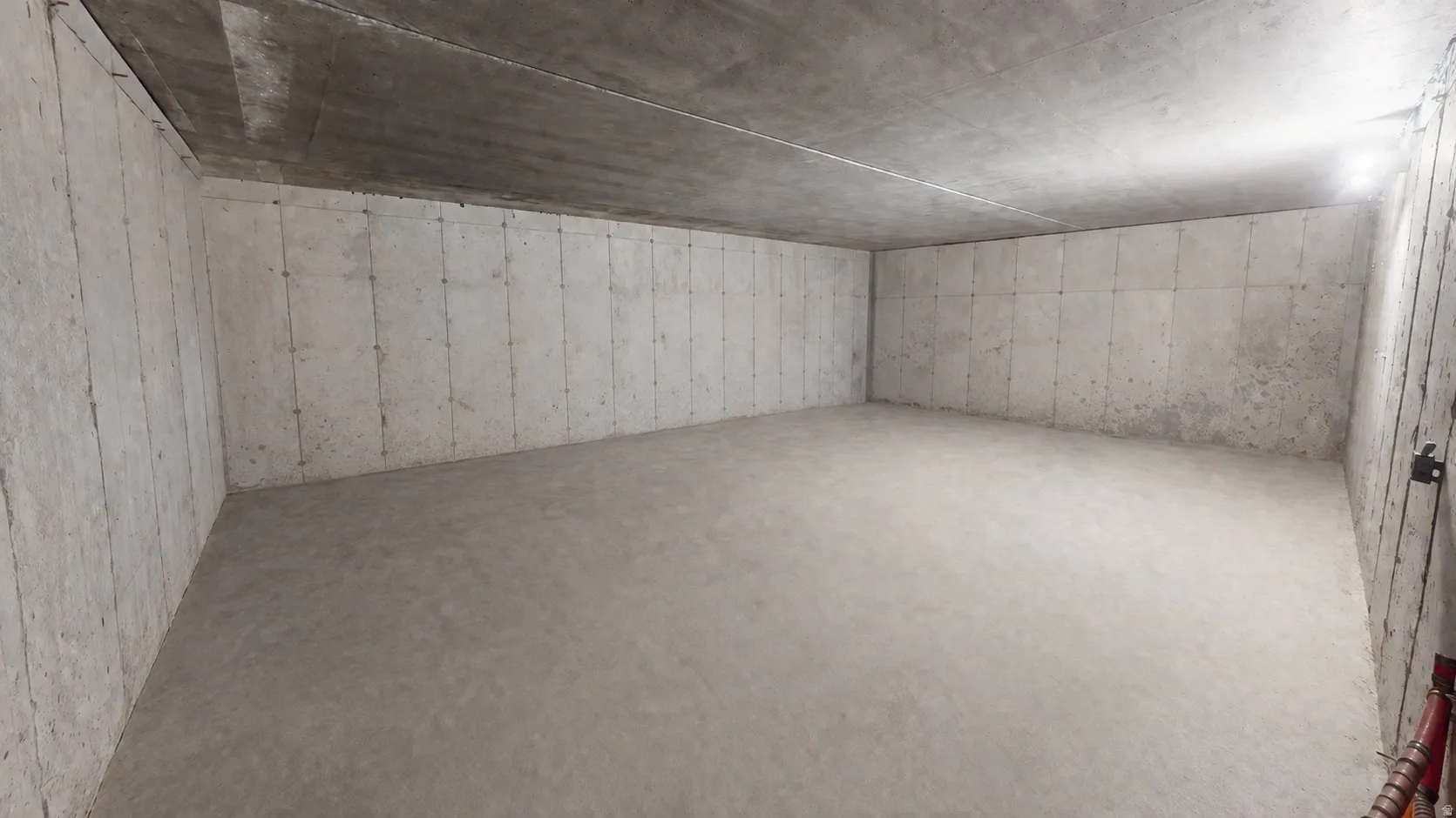 This is an Ai enhanced Photo. Unfinished space featuring concrete walls, concrete flooring, and an exposed concrete ceiling