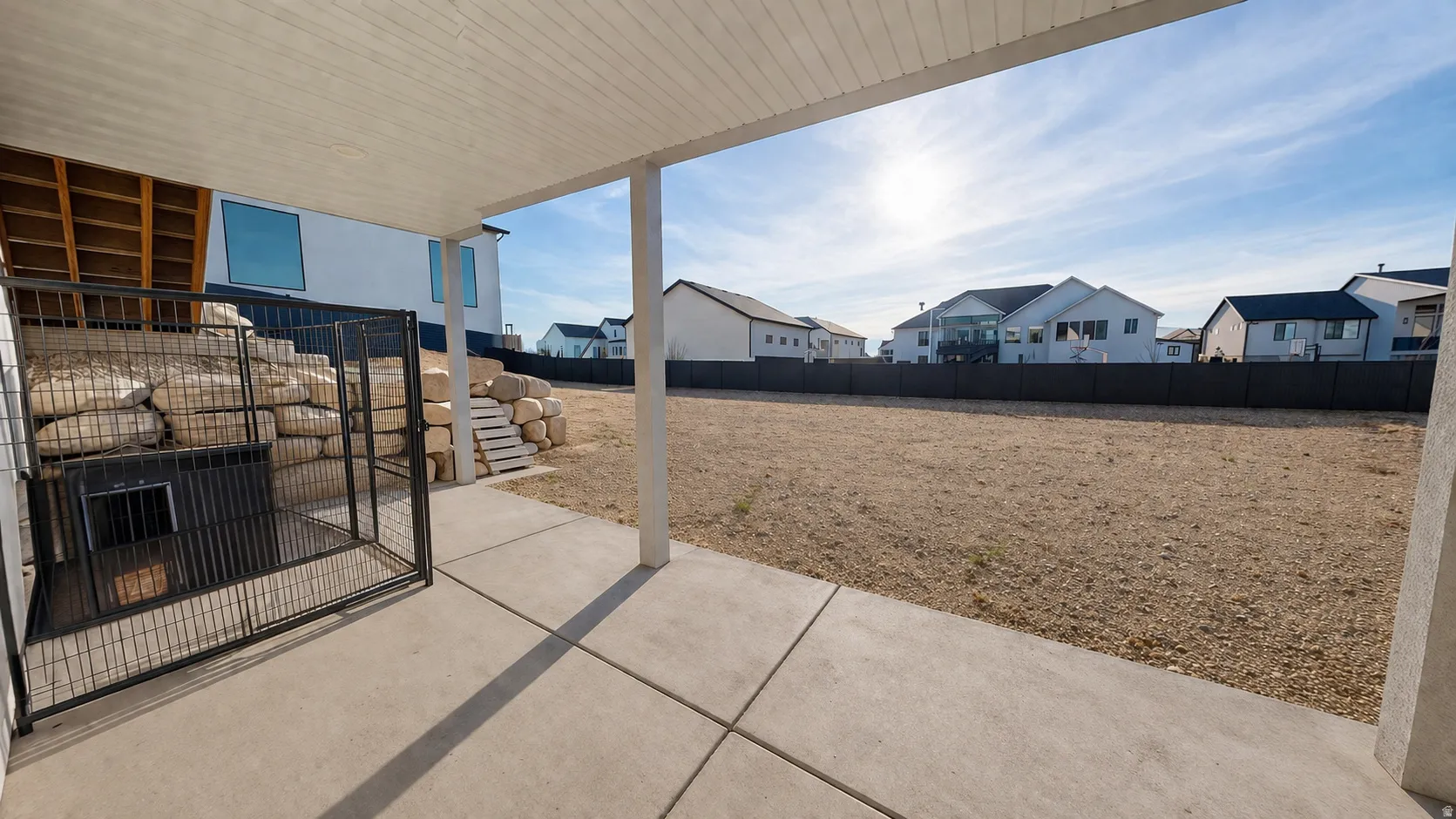 This is an Ai enhanced Photo. Covered patio with concrete flooring, terraced landscaping with stone retaining walls, and a fenced exterior