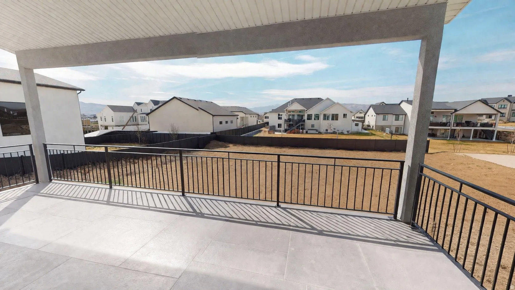 This is an Ai enhanced Photo. Covered outdoor patio with a concrete surface and black metal railings