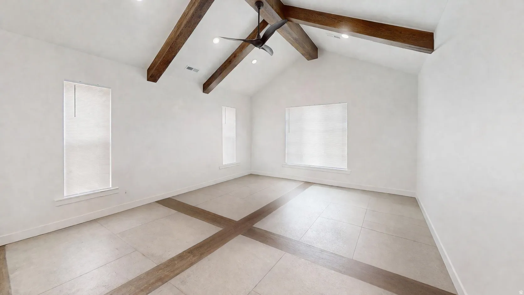 Vaulted ceiling with exposed wood beams and recessed lighting